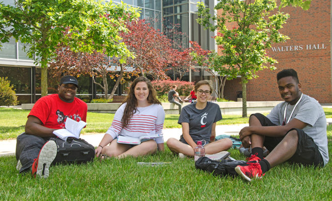 UCBA students sit on the grass.