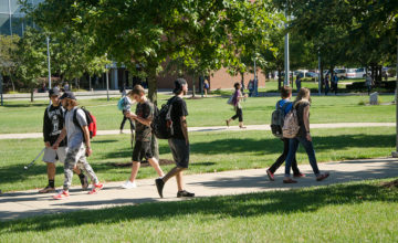 Students walk along a sidewalk