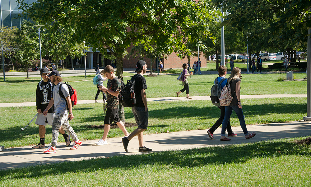 Students walk along a sidewalk
