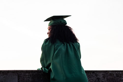 a young graduating woman looks out into the distance.