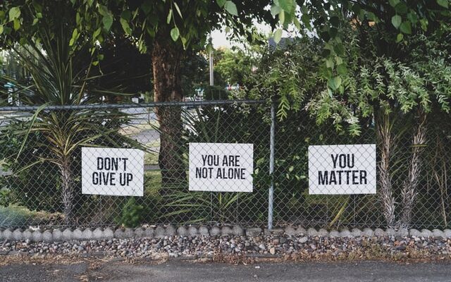 Signs with text: Don't give up; you are not alone; you matter